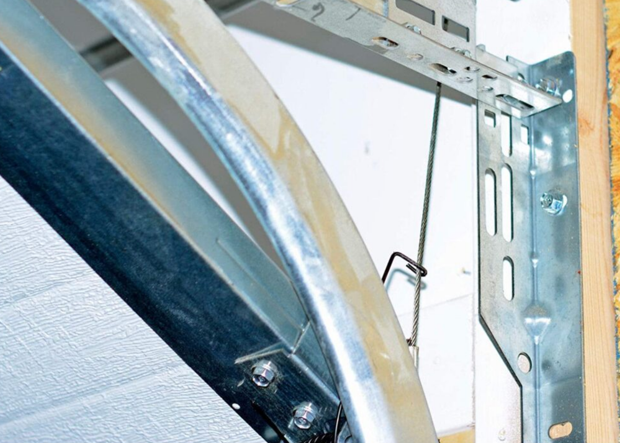 a professional technician performing garage door track repair in Weston, FL, showcasing tools and expertise in restoring garage door functionality."